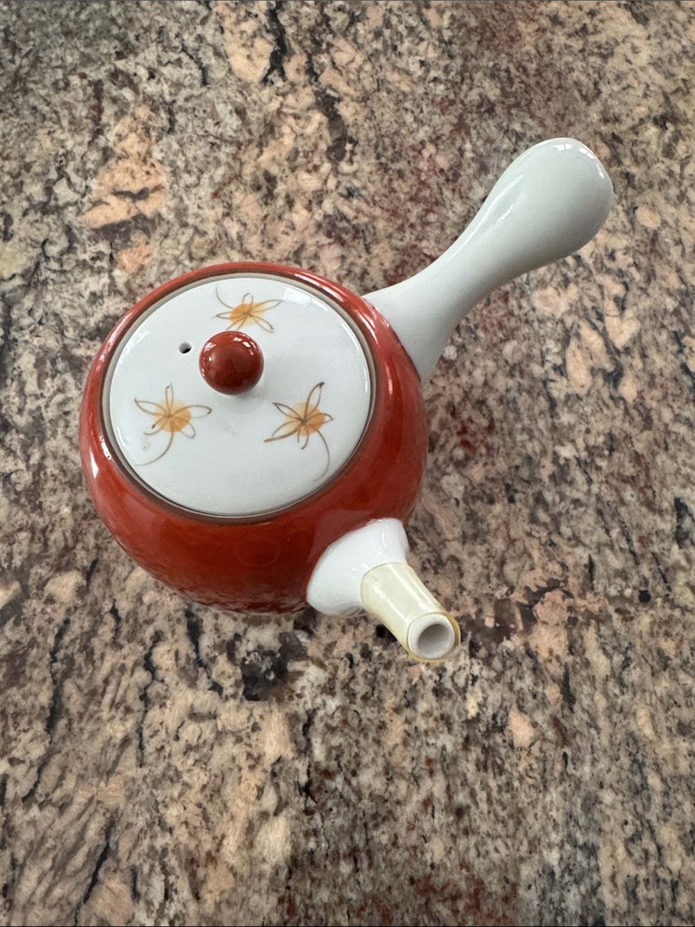 Red Ceramic Teapot with White Handle and Floral Lid and tea leaf strainer